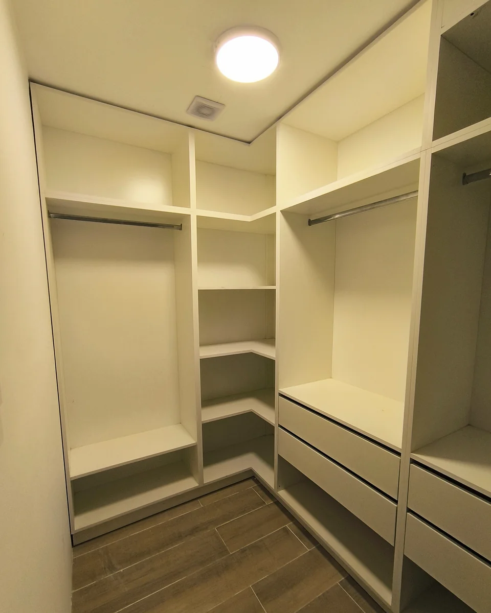 Vestidor abierto con estantes, cajones y espacio de colgado.