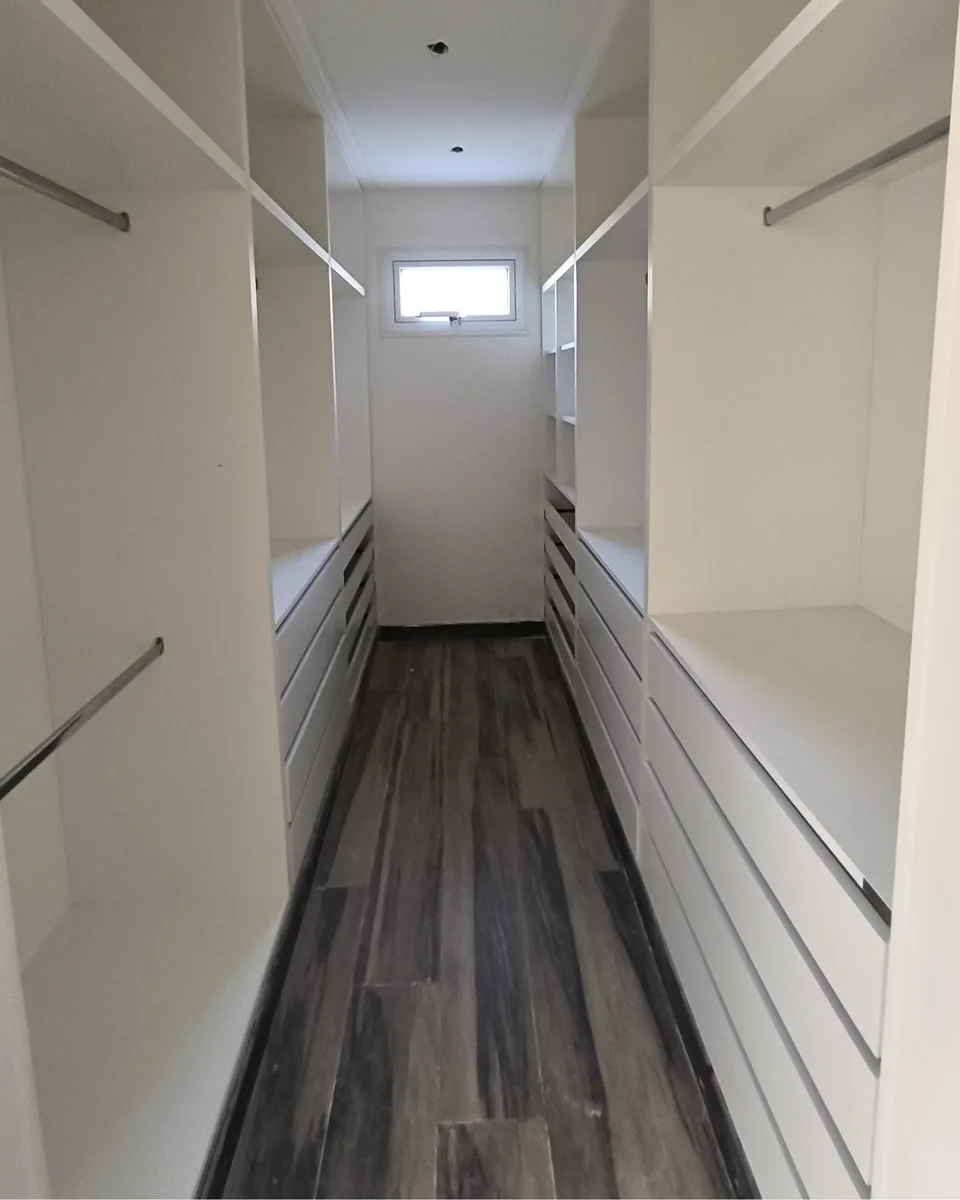 Vestidor con guardado a ambos lados del ambiente.